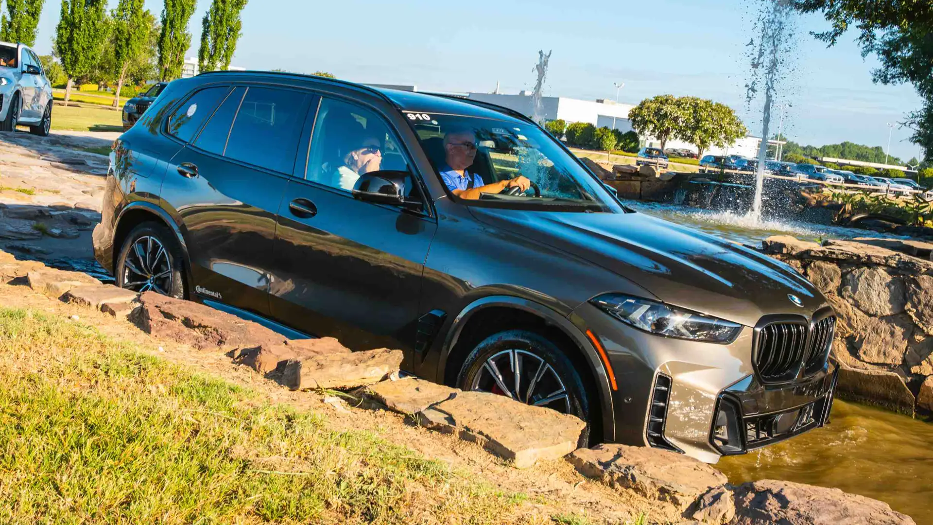 BMW X5 easing over a rock ledge in the water feature