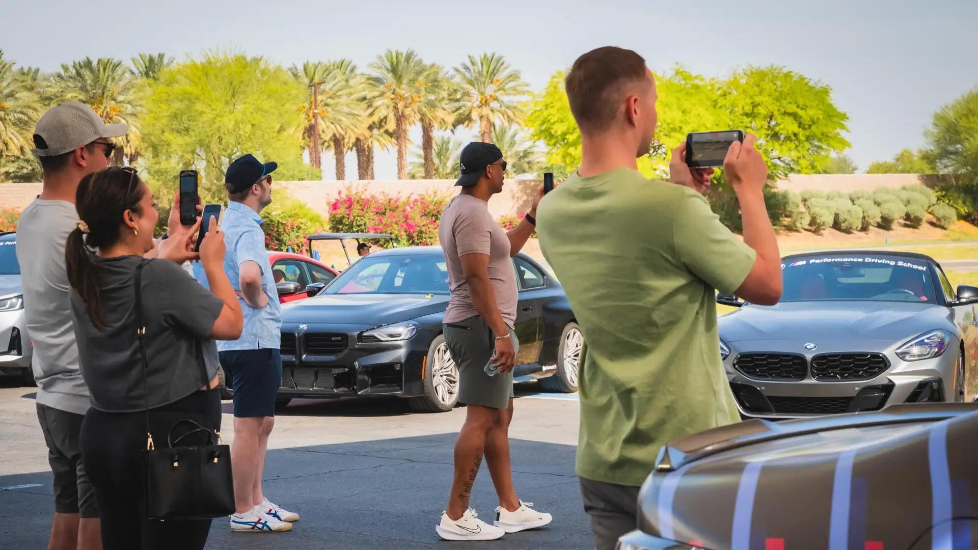 Group photographing a line-up of BMWs in the desert paddock