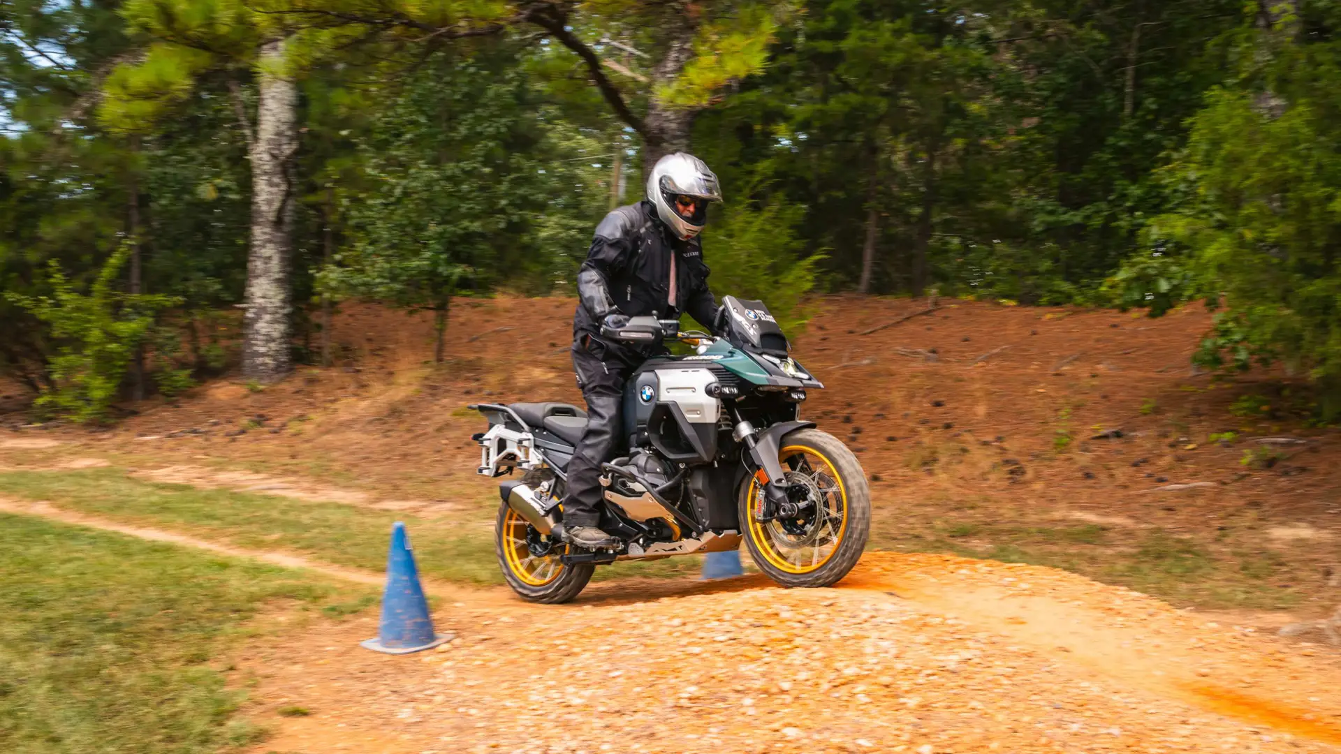 Rider on a BMW GS riding a dirt trail marked with cones