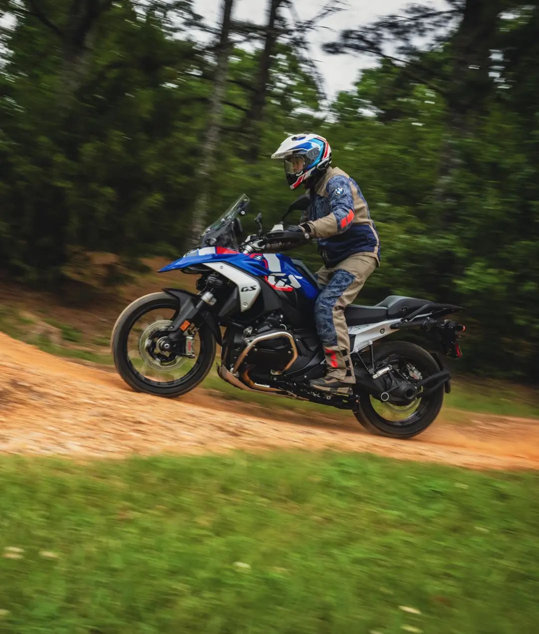 Rider on a BMW GS riding a dirt trail through the woods