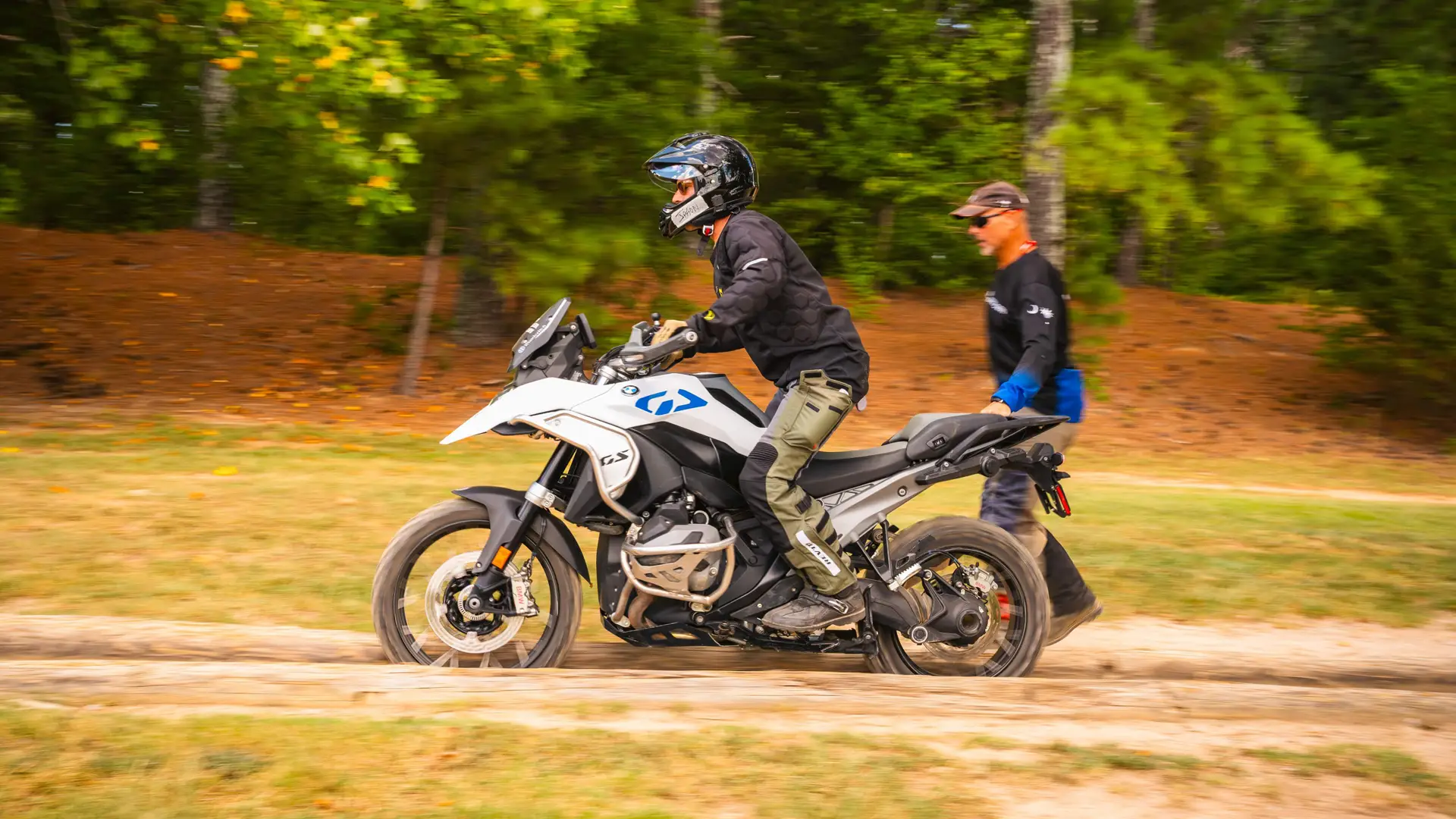Rider on a BMW GS along a dirt track with an instructor alongside