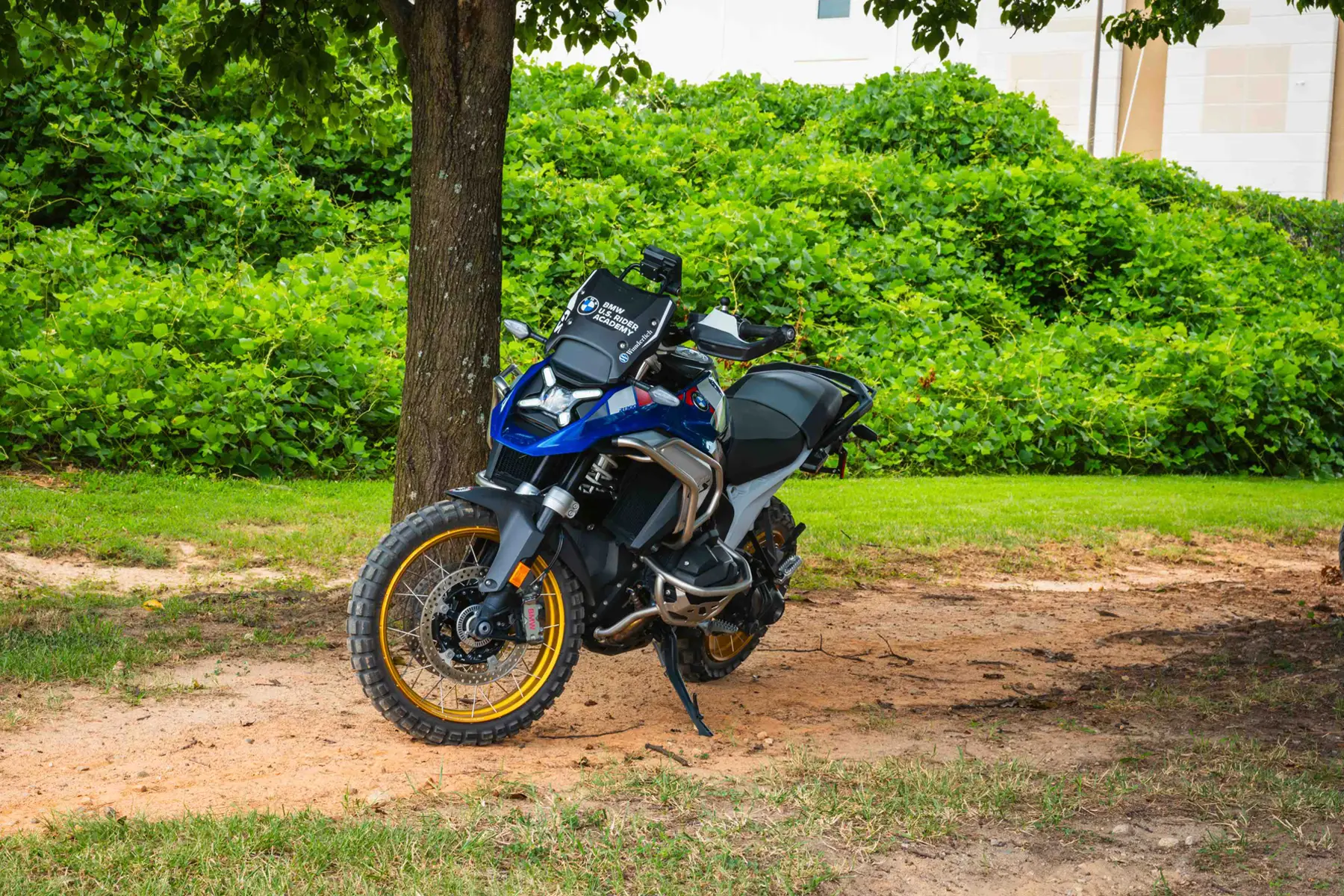 BMW GS parked in the shade of a tree beside the training area