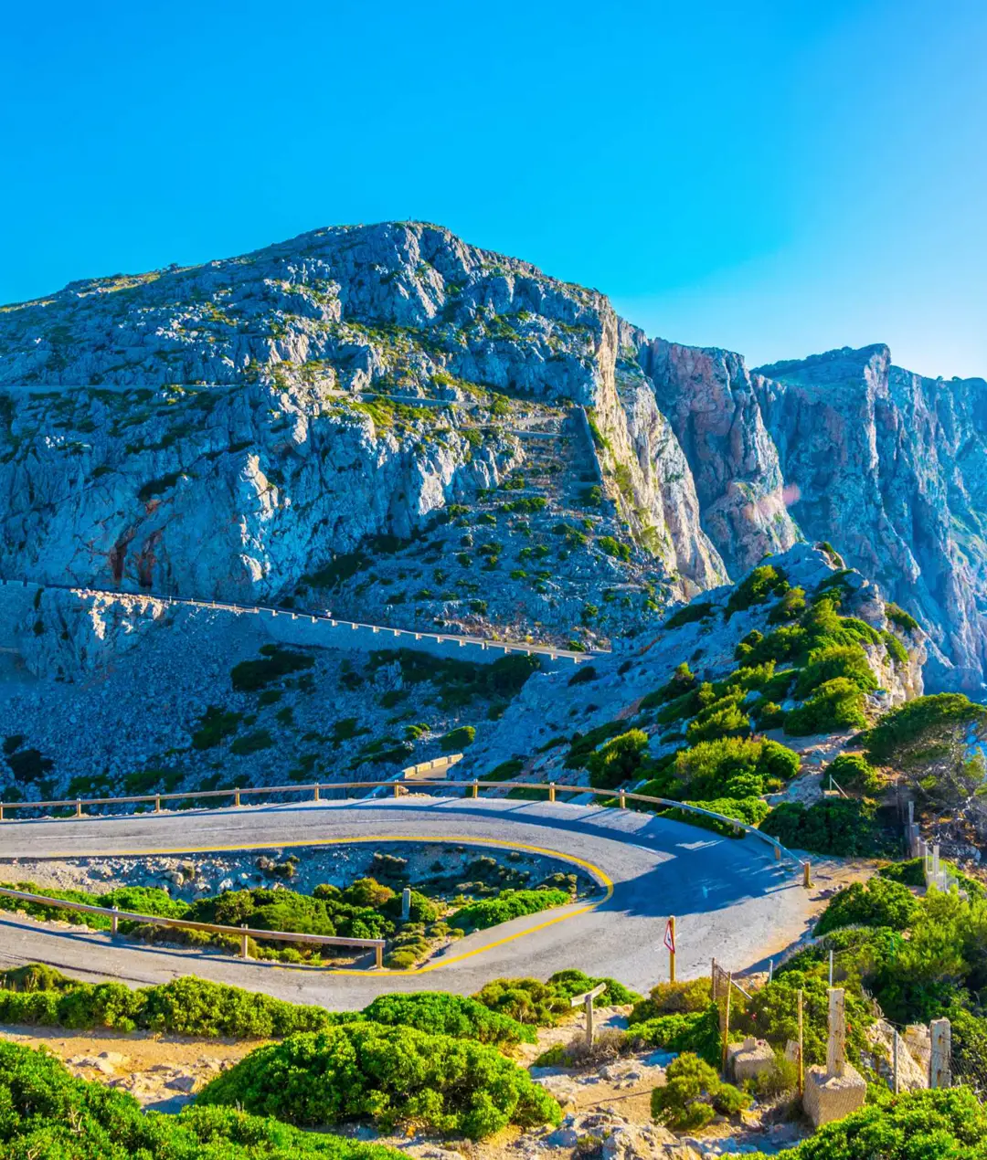 Hairpin bend on a road cut into rocky coastal mountains