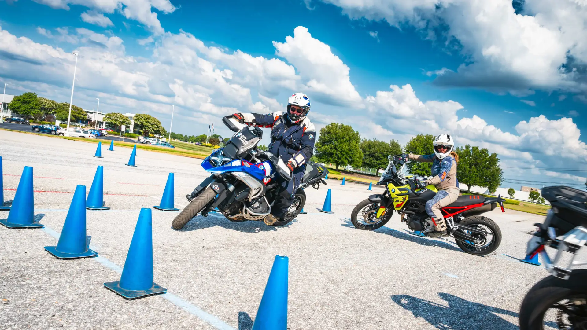 Two riders leaning hard through a blue cone course