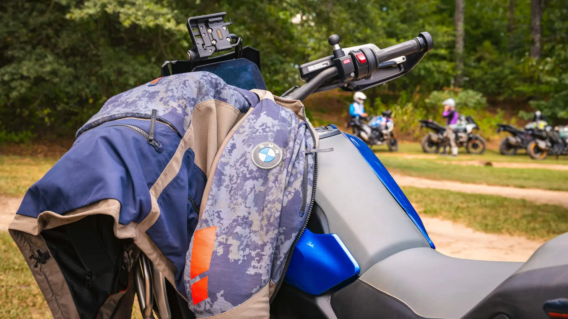 BMW riding jacket resting on the tank of a GS with riders behind