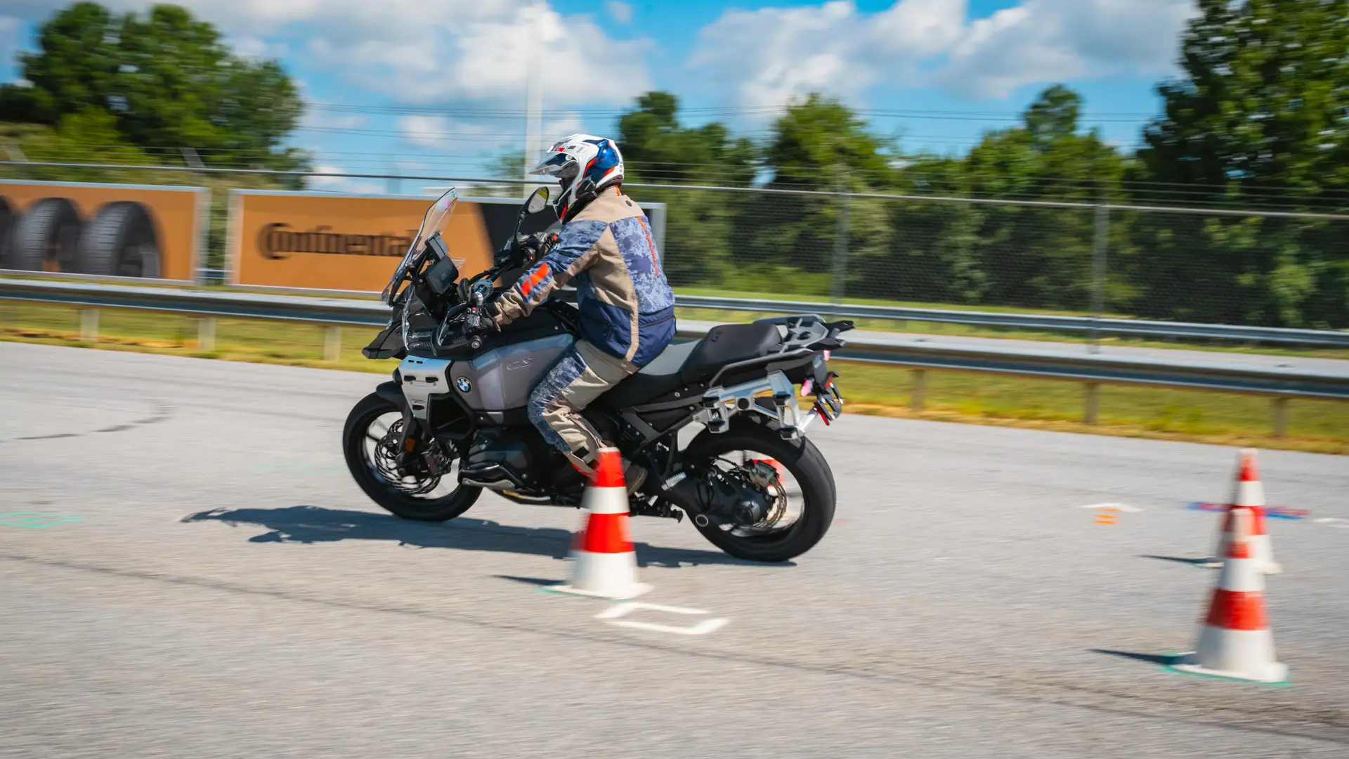 Rider weaving a BMW GS between orange cones on the training pad