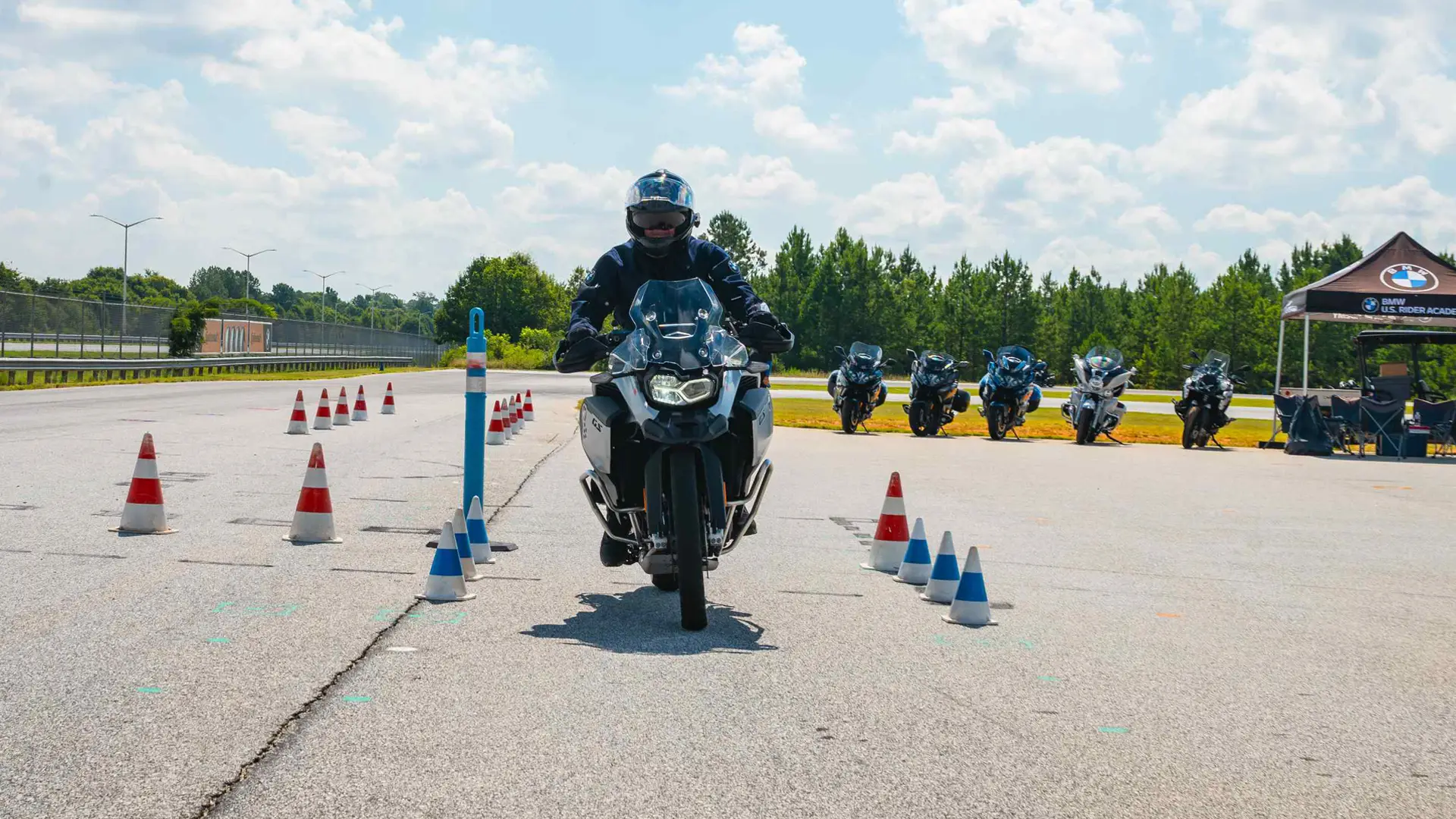 Rider on a BMW touring motorcycle threading a narrow cone gate