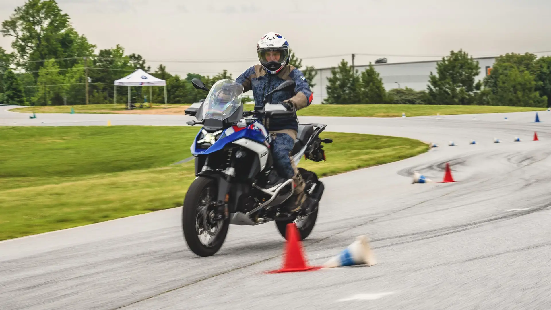 Rider braking hard on a BMW GS beside a knocked-over cone