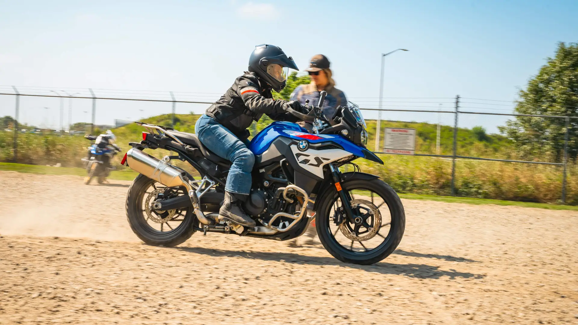 Rider practising emergency braking on a BMW GS while an instructor watches