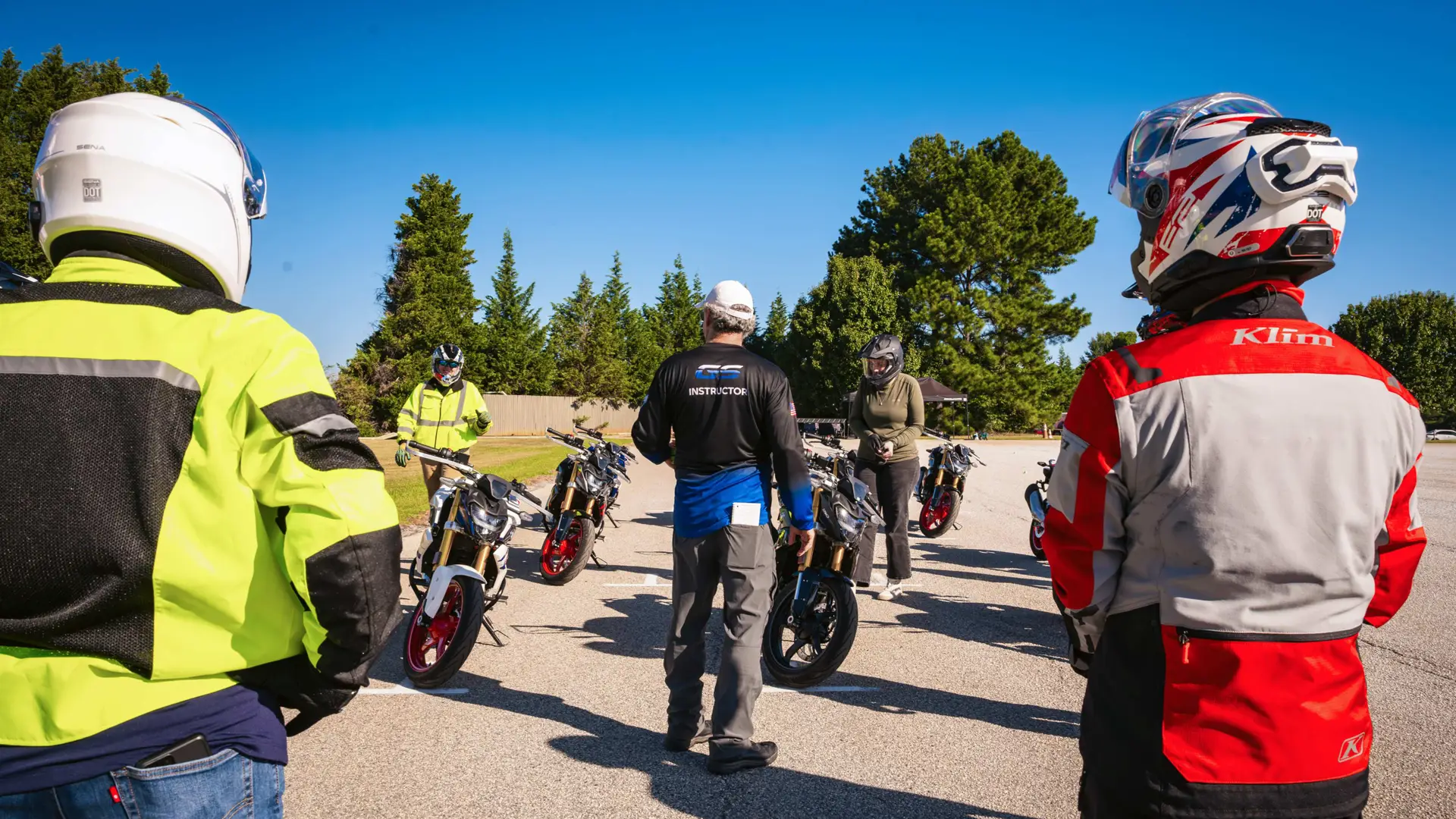 Riders watching an instructor walk out to a line of BMW motorcycles