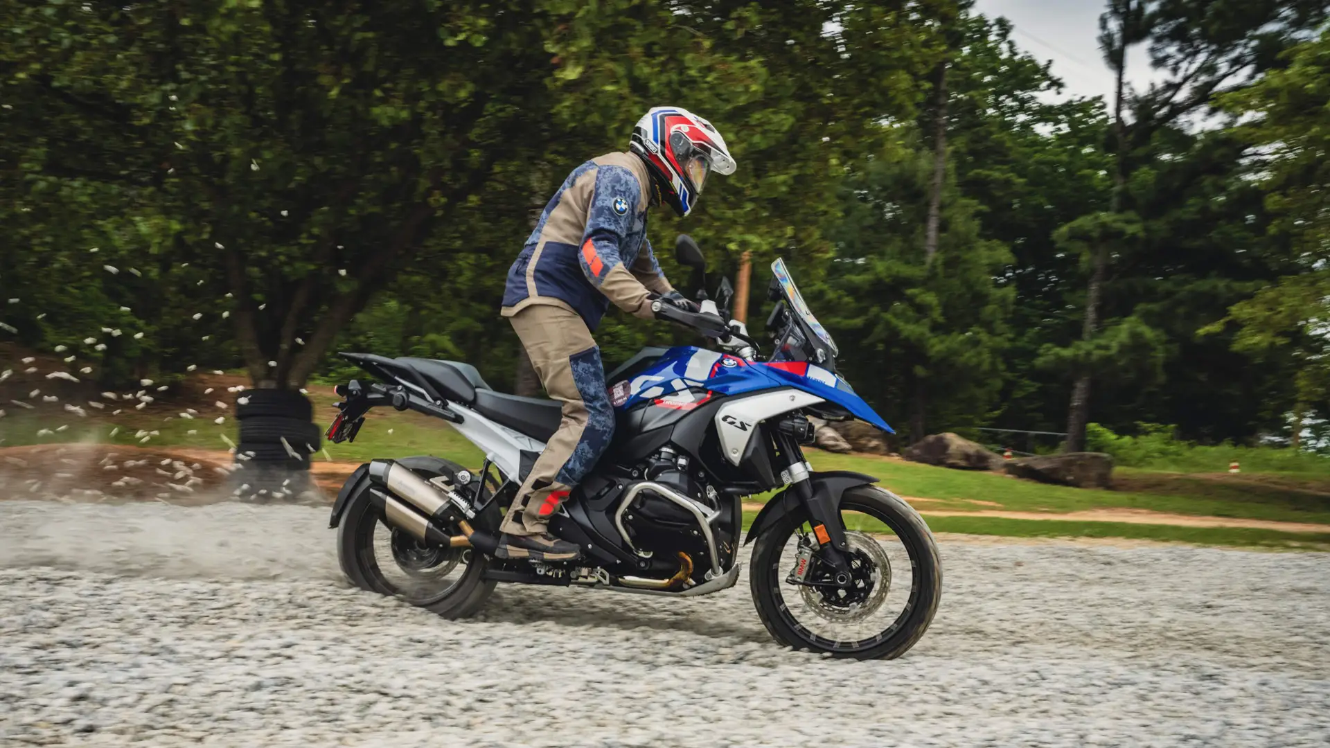 Rider spraying gravel on a BMW GS through a loose-surface section