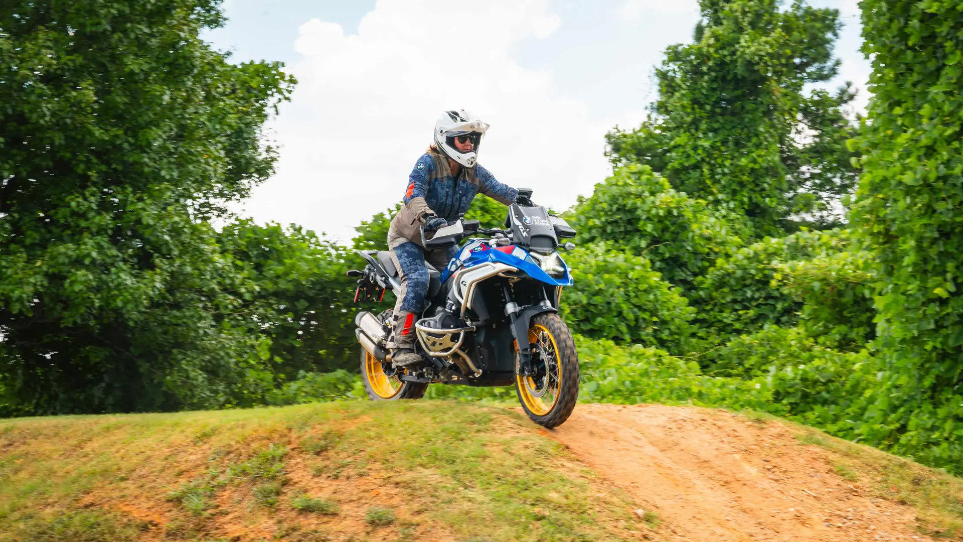 Rider cresting a dirt hill on a BMW GS