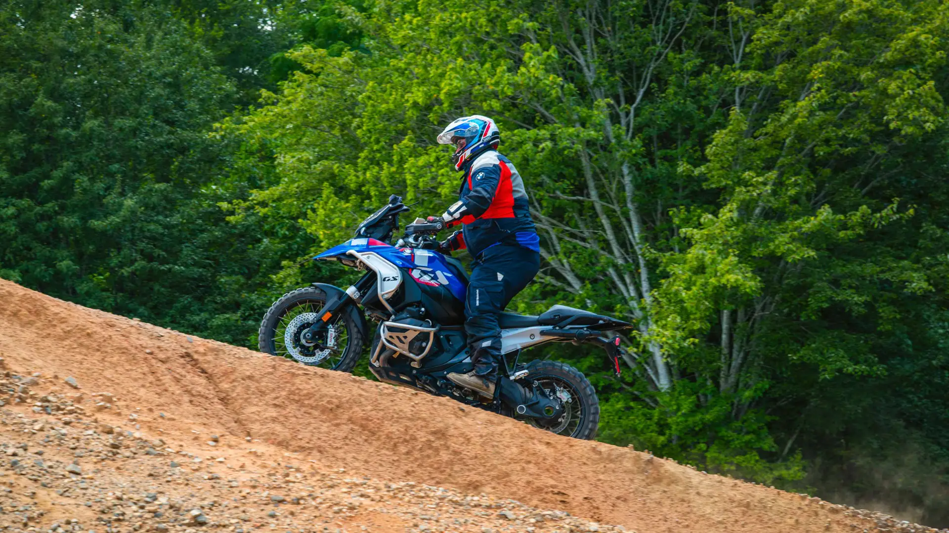 Rider easing a BMW GS down a steep dirt bank
