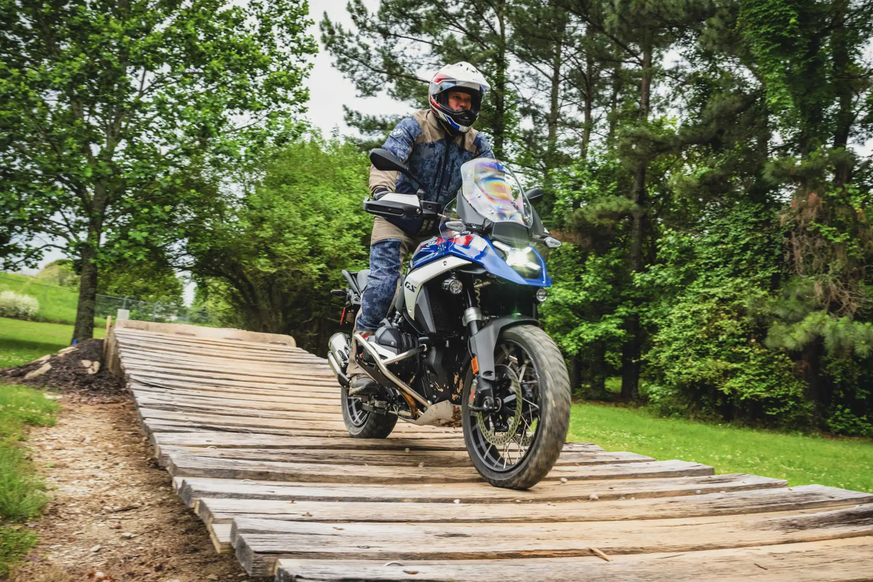 Rider crossing a wooden plank bridge on a BMW GS