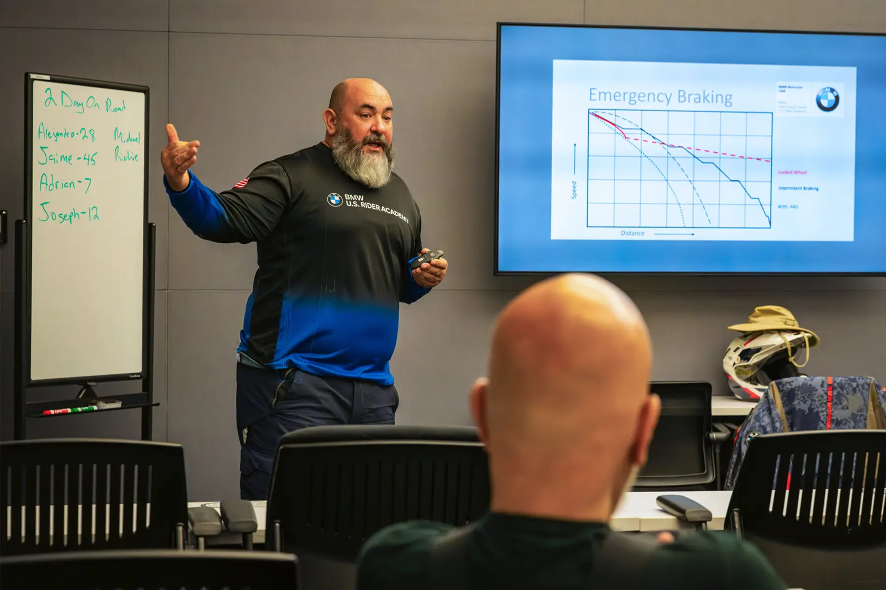 Instructor presenting an emergency braking chart to riders in the classroom