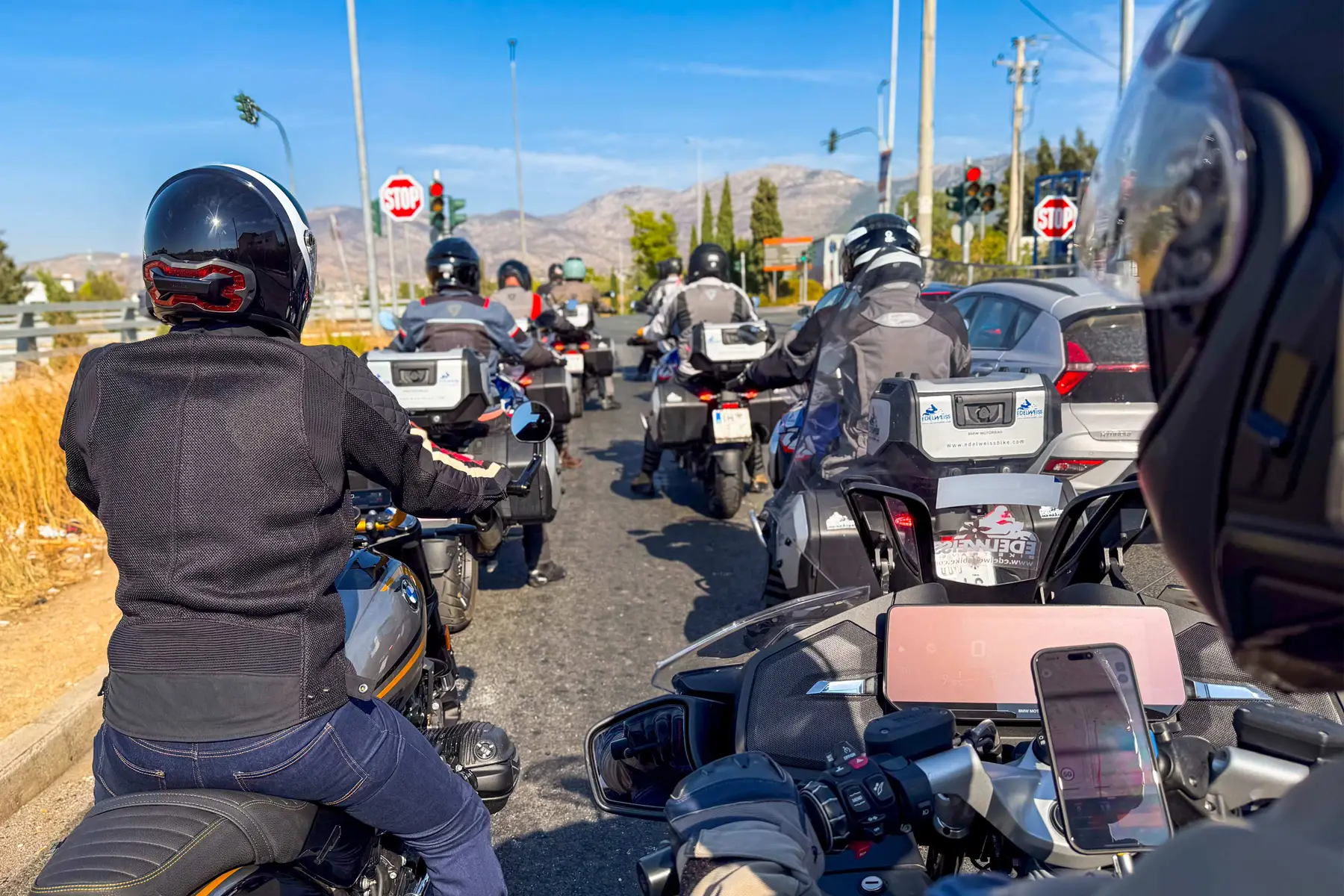 Riders waiting at a junction in a Spanish town, seen from the saddle