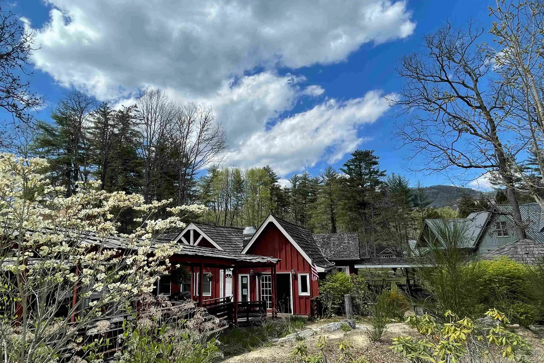 Red mountain cabin among dogwood blossom with hills behind
