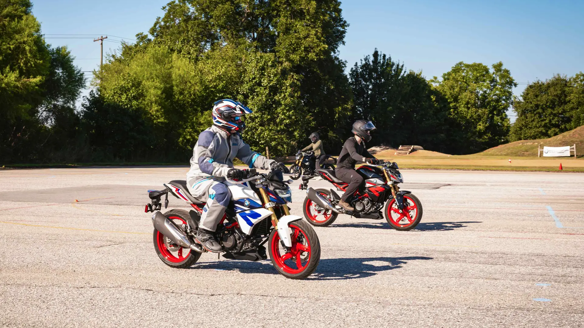 Three riders on BMW G 310 R motorcycles during a riding evaluation