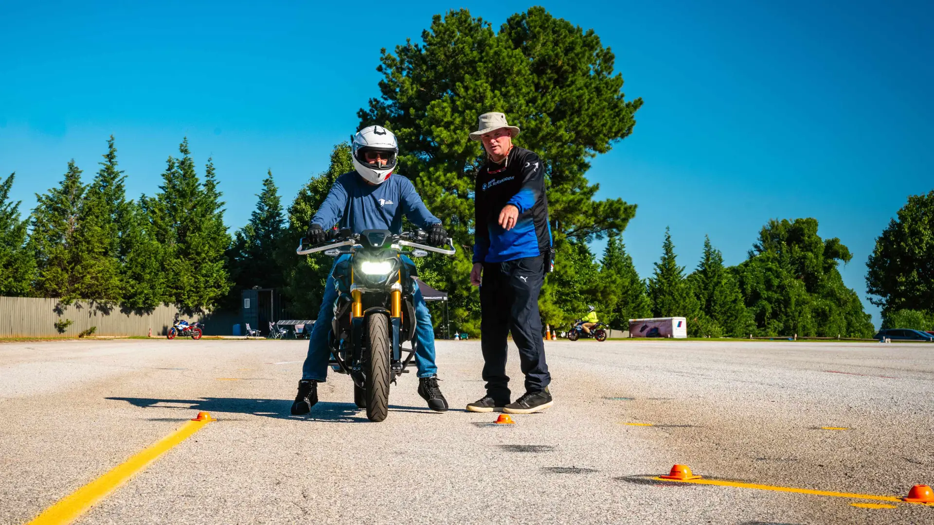 Instructor guiding a rider through a tight-space exercise marked with cones