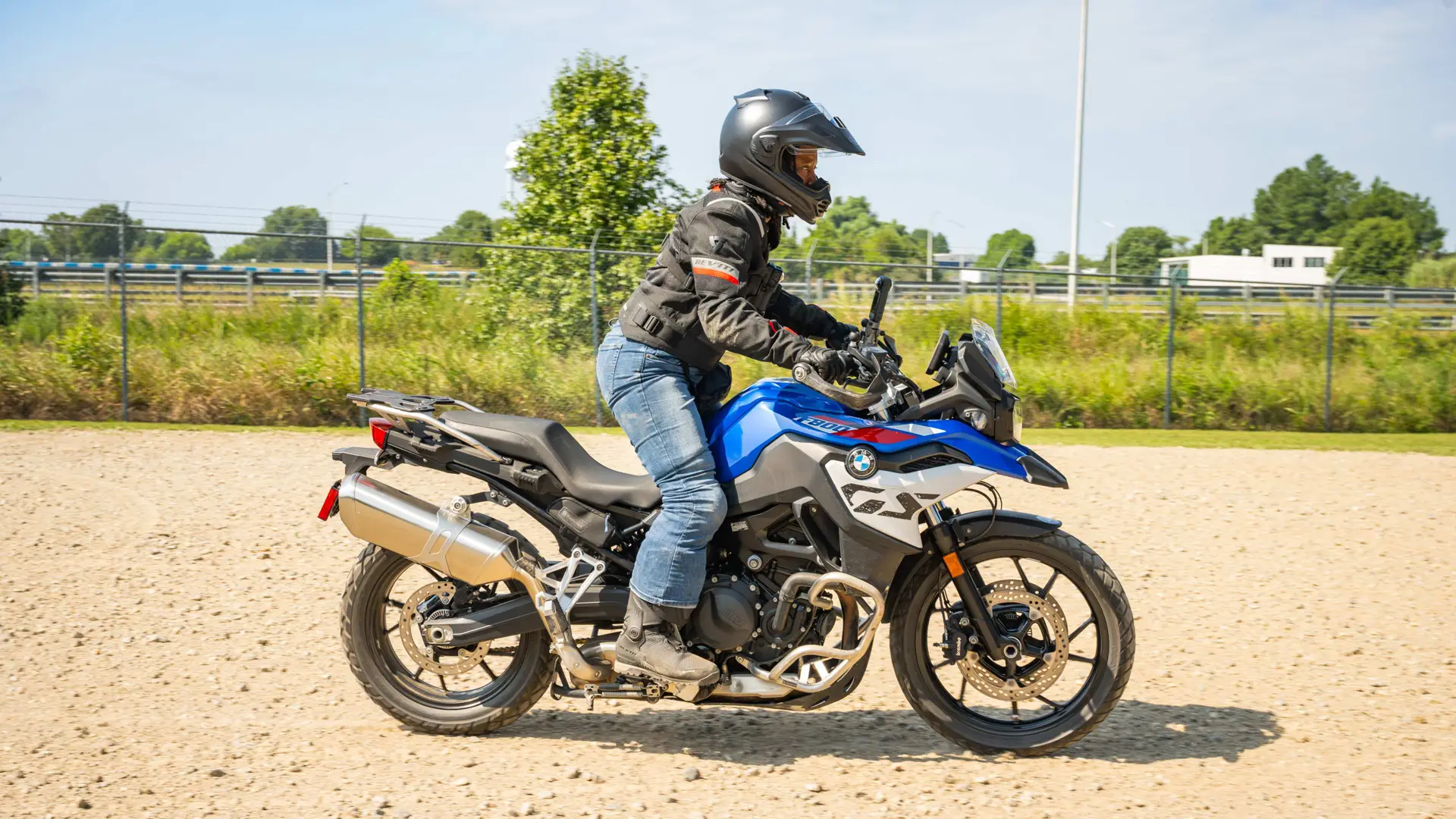 Rider bringing a BMW F 900 GS to a stop on gravel