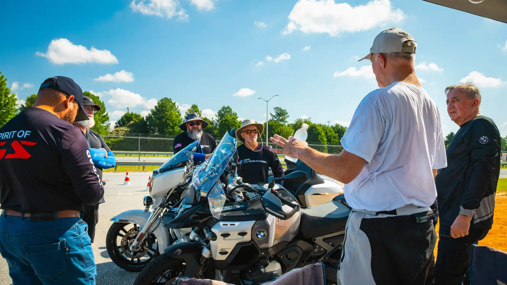 Instructor briefing a group of riders beside a BMW touring motorcycle