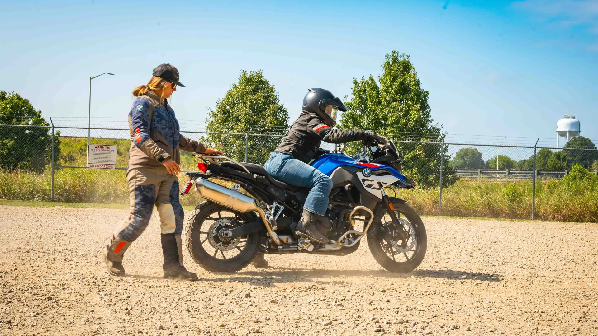 Instructor coaching a rider on a BMW GS on the gravel training area